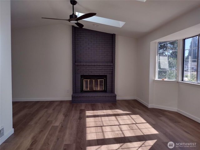 6245 S Huson St, Tacoma, WA 98409 - unfurnished living room featuring lofted ceiling, a ceiling fan, a brick fireplace, wood finished floors, and a skylight