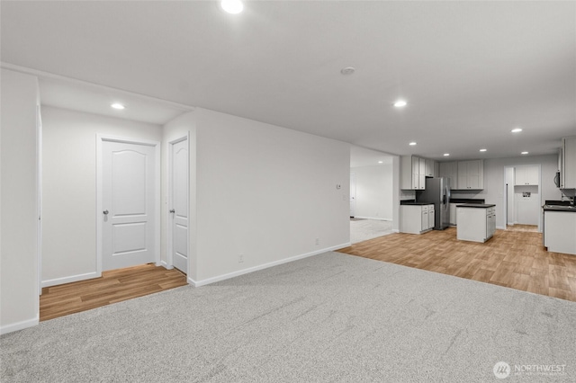 2120 77th Street Ct E, Tacoma, WA 98404 - unfurnished living room with recessed lighting, light colored carpet, and light wood-style floors