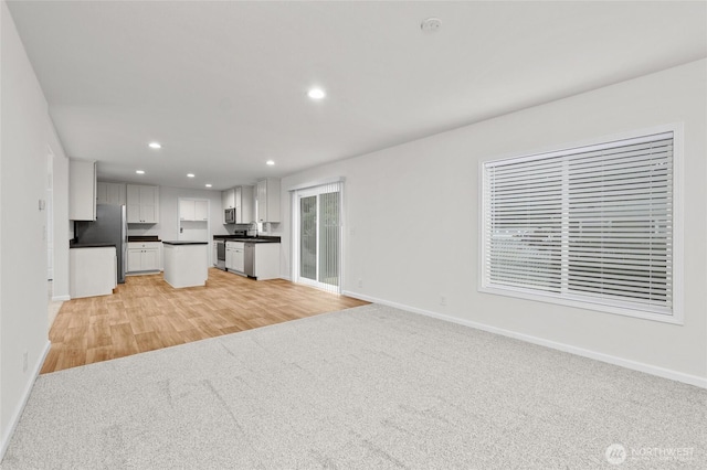 2120 77th Street Ct E, Tacoma, WA 98404 - unfurnished living room with recessed lighting, light carpet, and light wood finished floors