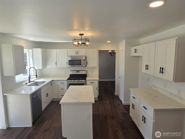 7106 201st St E, Spanaway, WA 98387 - kitchen with appliances with stainless steel finishes, a kitchen island, recessed lighting, dark wood-style floors, and white cabinetry