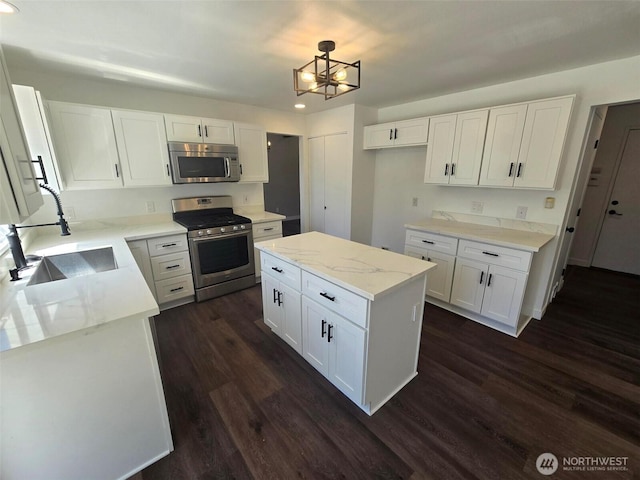 7106 201st St E, Spanaway, WA 98387 - kitchen featuring appliances with stainless steel finishes, dark wood finished floors, white cabinetry, and recessed lighting