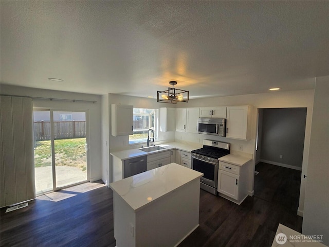 7106 201st St E, Spanaway, WA 98387 - kitchen with appliances with stainless steel finishes, a chandelier, white cabinets, healthy amount of natural light, and a textured ceiling