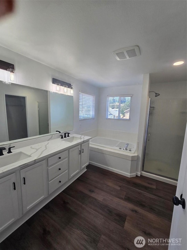 7106 201st St E, Spanaway, WA 98387 - bathroom featuring a stall shower, double vanity, a garden tub, and wood finished floors