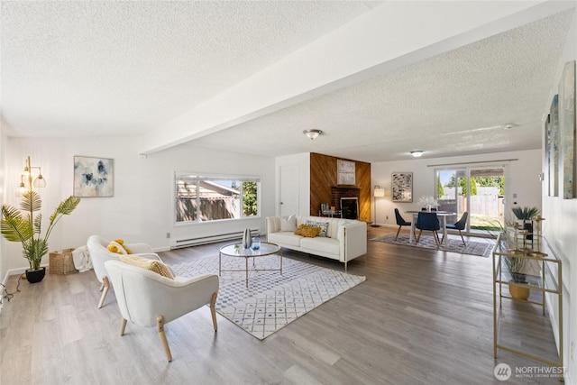 19520 Grannis Rd, Bothell, WA 98012 - living room with baseboard heating, a textured ceiling, healthy amount of natural light, wood finished floors, and a large fireplace