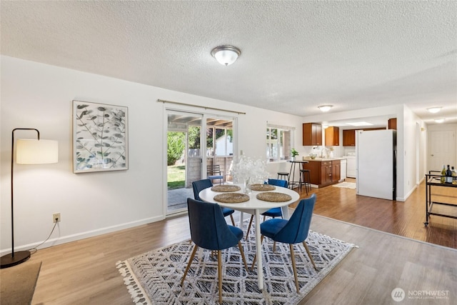 19520 Grannis Rd, Bothell, WA 98012 - dining space with light wood-type flooring, washer / clothes dryer, and a textured ceiling