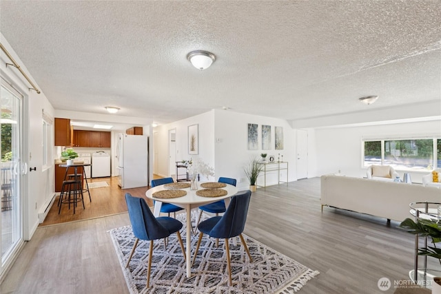 19520 Grannis Rd, Bothell, WA 98012 - dining area featuring light wood finished floors, a textured ceiling, washer / dryer, and healthy amount of natural light