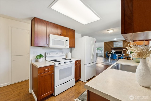 19520 Grannis Rd, Bothell, WA 98012 - kitchen featuring white appliances, a fireplace, light wood-style flooring, light countertops, and brown cabinetry