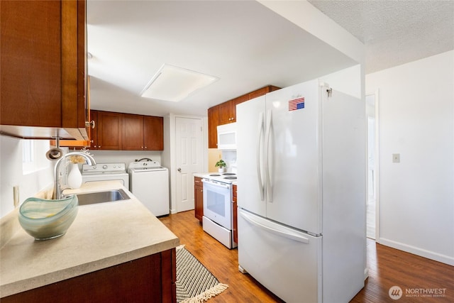 19520 Grannis Rd, Bothell, WA 98012 - kitchen featuring white appliances, washer and clothes dryer, light countertops, and light wood-type flooring