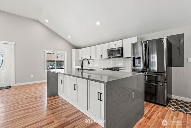 970 9th Ave, Longview, WA 98632 - kitchen featuring stainless steel appliances, white cabinetry, light wood-type flooring, electric panel, and a center island with sink