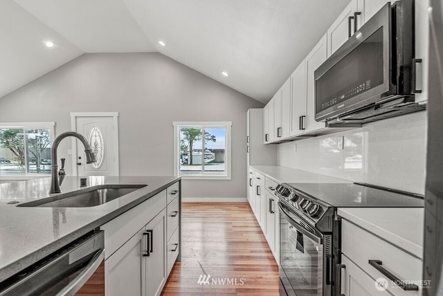 970 9th Ave, Longview, WA 98632 - kitchen featuring black / electric stove, dishwasher, plenty of natural light, vaulted ceiling, and recessed lighting