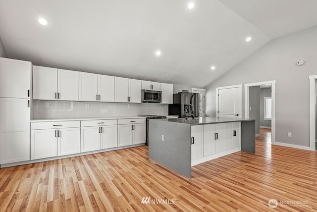 970 9th Ave, Longview, WA 98632 - kitchen with appliances with stainless steel finishes, light wood-style floors, white cabinetry, a kitchen island with sink, and recessed lighting