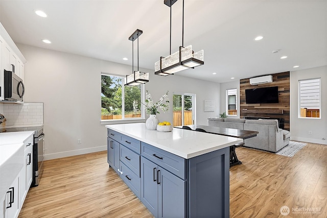 10111 12th Ave E, Tacoma, WA 98445 - kitchen featuring appliances with stainless steel finishes, white cabinets, light wood-style flooring, recessed lighting, and a wall mounted air conditioner