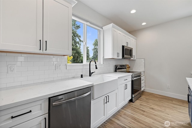 10111 12th Ave E, Tacoma, WA 98445 - kitchen with stainless steel appliances, plenty of natural light, white cabinets, recessed lighting, and light stone counters