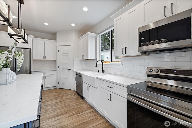 10111 12th Ave E, Tacoma, WA 98445 - kitchen featuring stainless steel appliances, white cabinetry, recessed lighting, light stone counters, and tasteful backsplash
