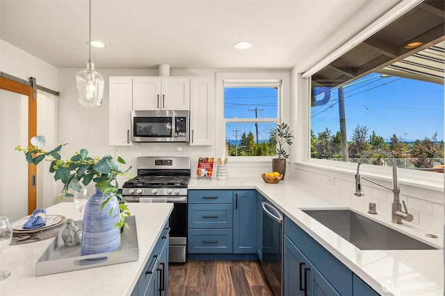 7554 34th Ave SW, Seattle, WA 98126 - kitchen featuring stainless steel appliances, decorative backsplash, white cabinetry, recessed lighting, and hanging light fixtures