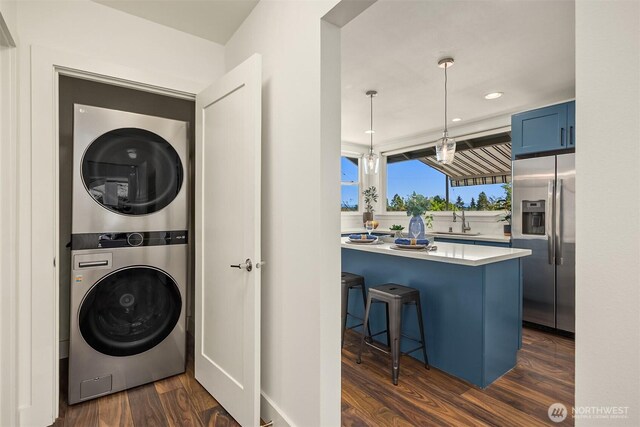 7554 34th Ave SW, Seattle, WA 98126 - laundry area featuring estacked washer and dryer, dark wood finished floors, and recessed lighting