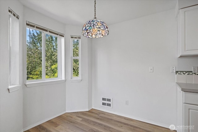 2448 NW 59th St Unit 301, Seattle, WA 98107 - unfurnished dining area featuring wood finished floors and baseboards