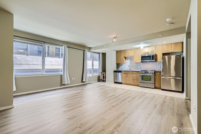 76 Cedar St Unit 806, Seattle, WA 98121 - kitchen featuring stainless steel appliances, decorative backsplash, light wood finished floors, dark countertops, and light brown cabinets