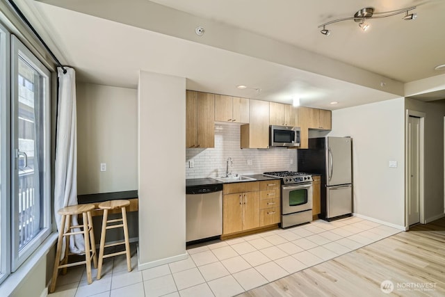 76 Cedar St Unit 806, Seattle, WA 98121 - kitchen featuring appliances with stainless steel finishes, decorative backsplash, dark countertops, and light wood-style flooring