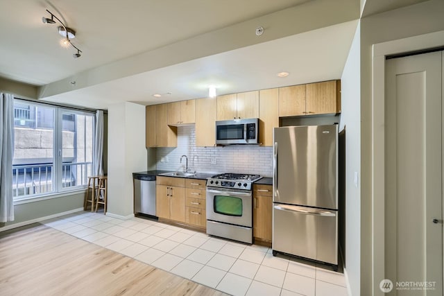 76 Cedar St Unit 806, Seattle, WA 98121 - kitchen featuring appliances with stainless steel finishes, dark countertops, decorative backsplash, light wood-type flooring, and light brown cabinetry