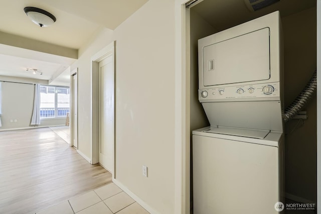 76 Cedar St Unit 806, Seattle, WA 98121 - laundry area with stacked washer / drying machine and light tile patterned flooring