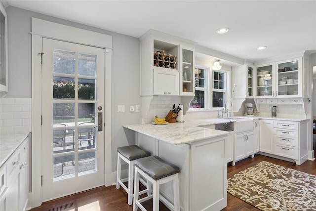 4712 90th Ave SE, Mercer Island, WA 98040 - kitchen with decorative backsplash, white cabinetry, a kitchen breakfast bar, light stone counters, and recessed lighting