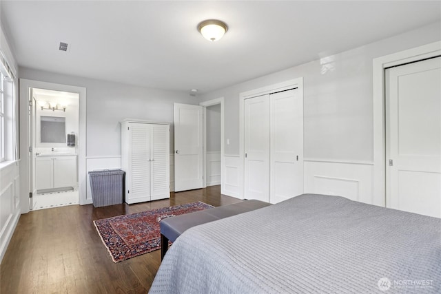4712 90th Ave SE, Mercer Island, WA 98040 - bedroom featuring dark wood finished floors, two closets, ensuite bath, and wainscoting
