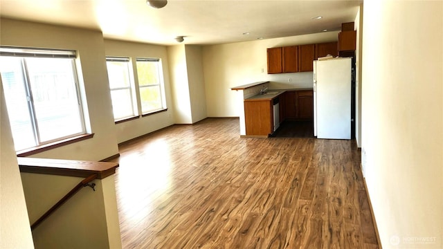 2316 Xenia St Unit 2316, Bellingham, WA 98229 - kitchen with freestanding refrigerator, dark wood-style floors, brown cabinetry, dishwasher, and open floor plan