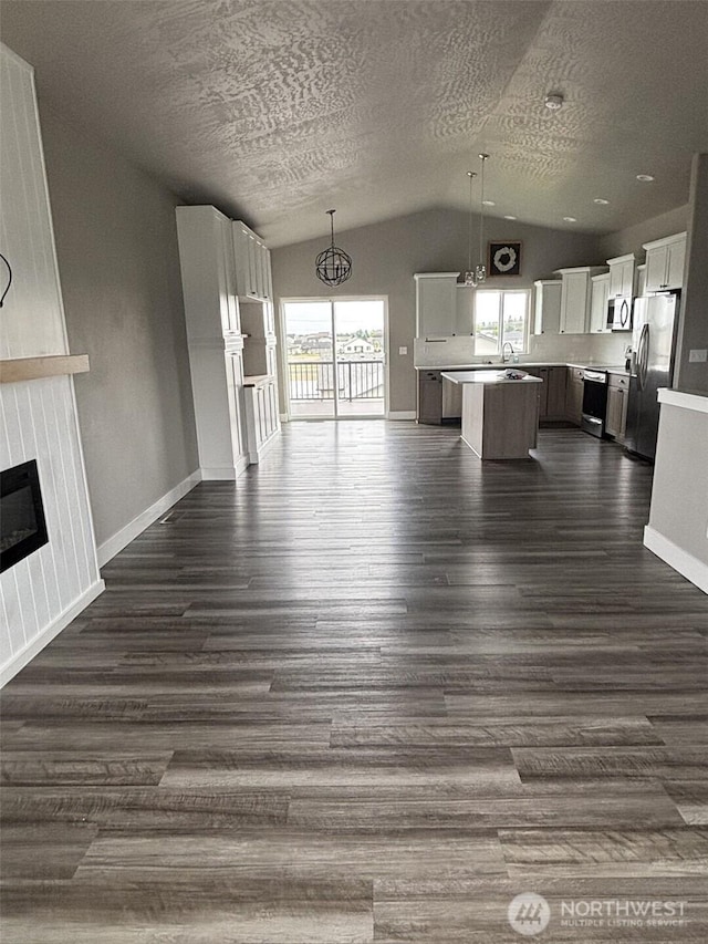 1522 E Marilyn Cir, Deer Park, WA 99006 - unfurnished living room featuring lofted ceiling, a fireplace, dark wood-type flooring, and a textured ceiling