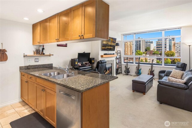 1420 Terry Ave Unit 1607, Seattle, WA 98101 - kitchen featuring open floor plan, dishwasher, a warm lit fireplace, brown cabinetry, and dark stone countertops