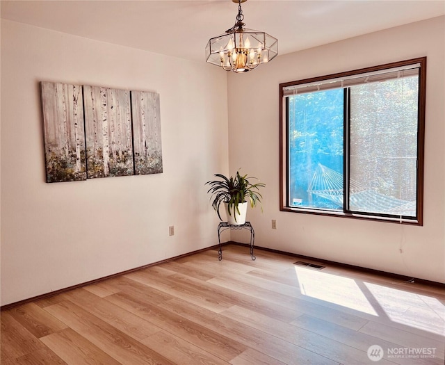 8123 129th Pl SE, Newcastle, WA 98056 - spare room featuring light wood-type flooring and a chandelier