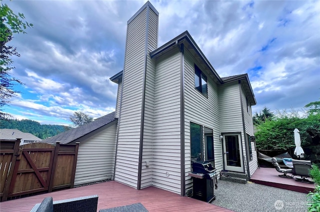 8123 129th Pl SE, Newcastle, WA 98056 - back of property featuring a wooden deck, a chimney, a gate, and a patio area