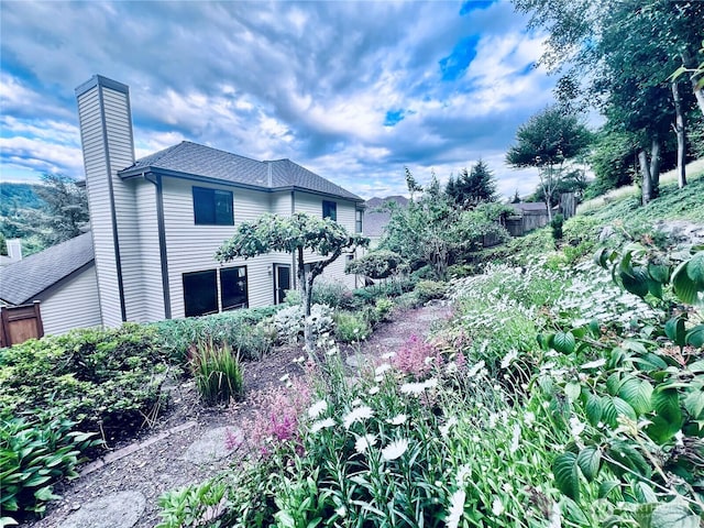8123 129th Pl SE, Newcastle, WA 98056 - view of side of home featuring a shingled roof and a chimney