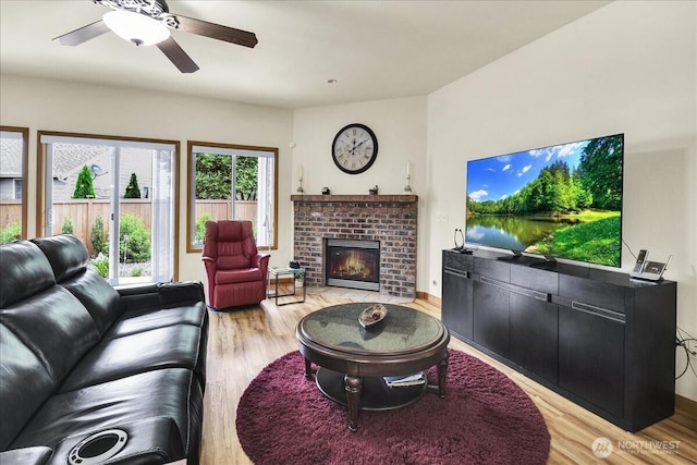 15203 148th Avenue Ct E, Orting, WA 98360 - living room with light wood-style floors, a brick fireplace, and ceiling fan