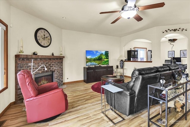 15203 148th Avenue Ct E, Orting, WA 98360 - living area with wood finished floors, ceiling fan, a brick fireplace, and arched walkways