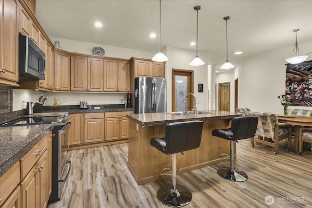 15203 148th Avenue Ct E, Orting, WA 98360 - kitchen featuring appliances with stainless steel finishes, light wood-type flooring, a breakfast bar area, hanging light fixtures, and recessed lighting