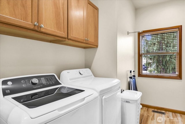 15203 148th Avenue Ct E, Orting, WA 98360 - laundry area featuring washer and clothes dryer, cabinet space, and light wood-style floors