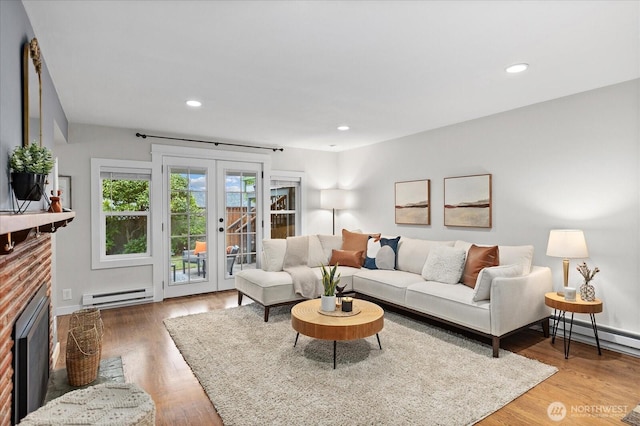 4301 1st Ave NW, Seattle, WA 98107 - living room with baseboard heating, french doors, recessed lighting, light wood-type flooring, and a brick fireplace