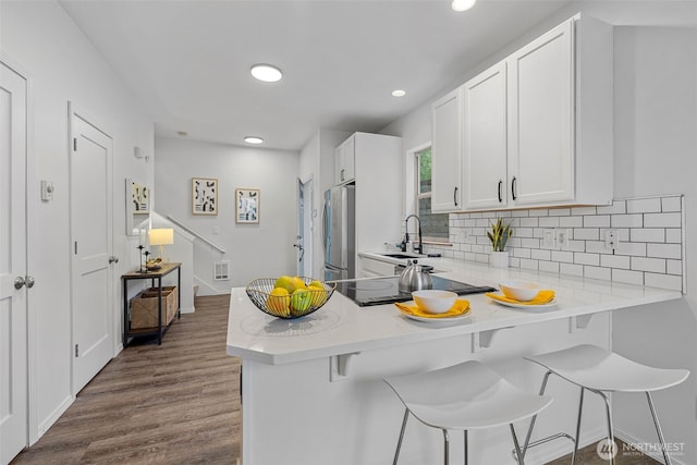 4802 Delridge Way SW, Seattle, WA 98106 - kitchen with freestanding refrigerator, black electric cooktop, dark wood-style flooring, decorative backsplash, and recessed lighting