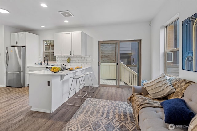 4802 Delridge Way SW, Seattle, WA 98106 - kitchen featuring freestanding refrigerator, wood finished floors, light countertops, white cabinetry, and recessed lighting