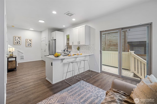 4802 Delridge Way SW, Seattle, WA 98106 - kitchen featuring freestanding refrigerator, dark wood-style flooring, light countertops, backsplash, and a peninsula