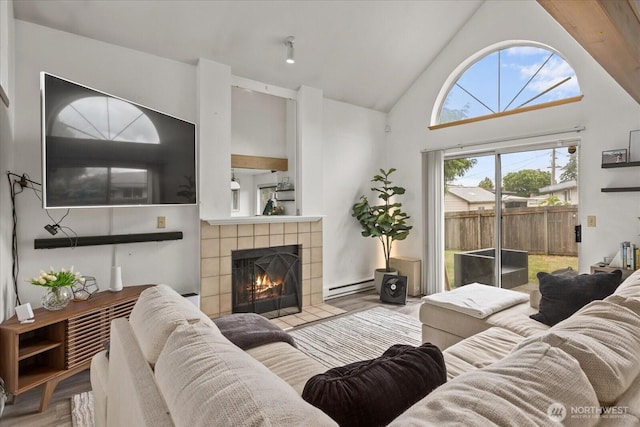 2826 NE 8th St, Renton, WA 98056 - living room featuring a baseboard radiator, a tiled fireplace, wood finished floors, and high vaulted ceiling