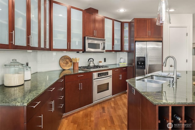 2033 2nd Ave Unit 703, Seattle, WA 98121 - kitchen with stainless steel appliances, light wood-style flooring, hanging light fixtures, dark stone counters, and recessed lighting