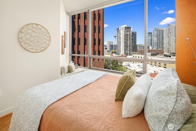 2033 2nd Ave Unit 703, Seattle, WA 98121 - bedroom featuring a skyline view, wood finished floors, and expansive windows