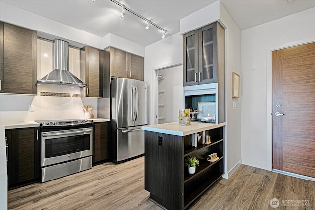 1760 NW 56th St Unit 520, Seattle, WA 98107 - kitchen with appliances with stainless steel finishes, wall chimney exhaust hood, open shelves, light countertops, and light wood-type flooring