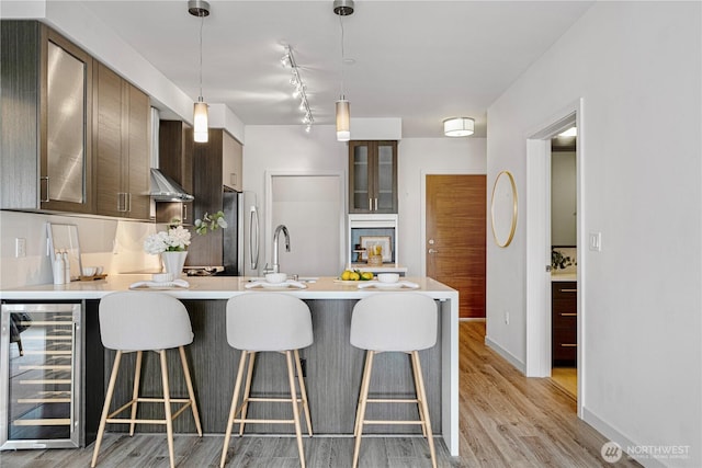 1760 NW 56th St Unit 520, Seattle, WA 98107 - kitchen featuring wine cooler, freestanding refrigerator, a peninsula, light countertops, and a breakfast bar area