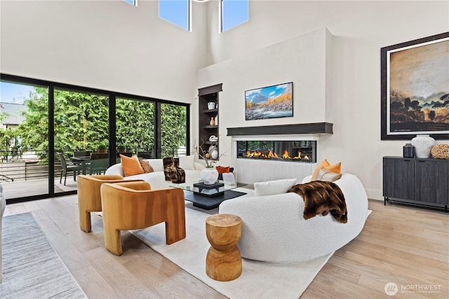 5515 108th Ave NE, Kirkland, WA 98033 - living area with wood finished floors, a glass covered fireplace, a high ceiling, and built in features