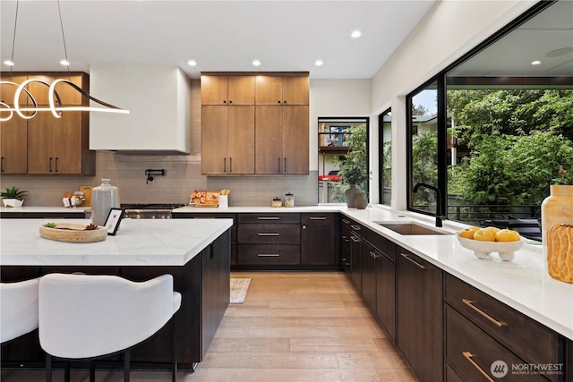 5515 108th Ave NE, Kirkland, WA 98033 - kitchen featuring light wood-style floors, tasteful backsplash, decorative light fixtures, a kitchen bar, and recessed lighting