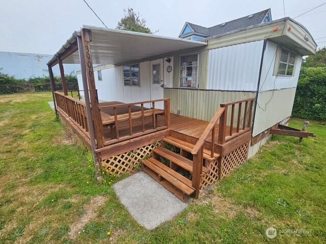 3906 L Pl, Seaview, WA 98644 - wooden deck with a lawn and an attached carport
