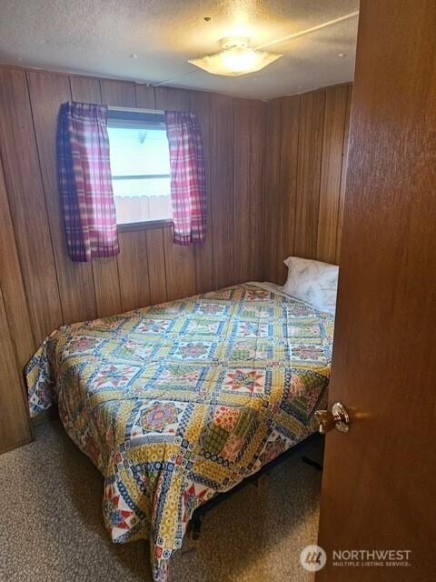 3906 L Pl, Seaview, WA 98644 - bedroom with carpet flooring, wooden walls, and a textured ceiling